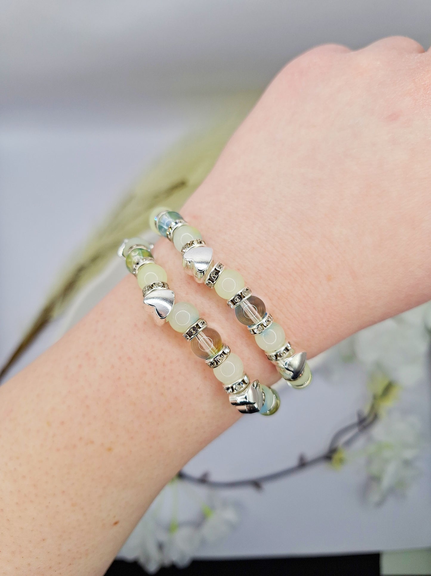 Elastisches Perlenarmband in Grün mit silbernen Perlen in Herzform